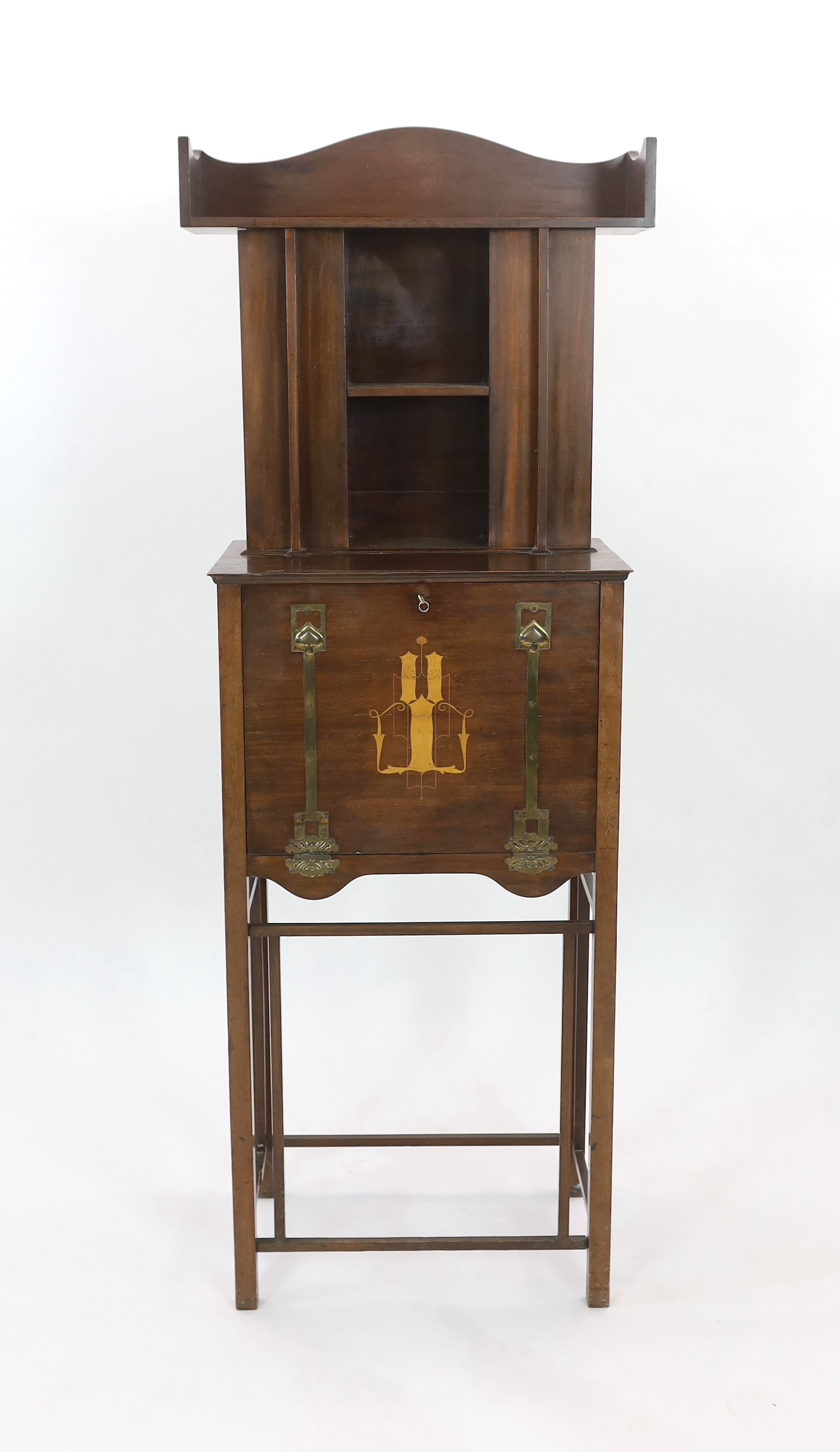 An early 20th century Arts & Crafts inlaid mahogany music cabinet, made by George Montague Ellwood and retailed by J.S. Henry of London